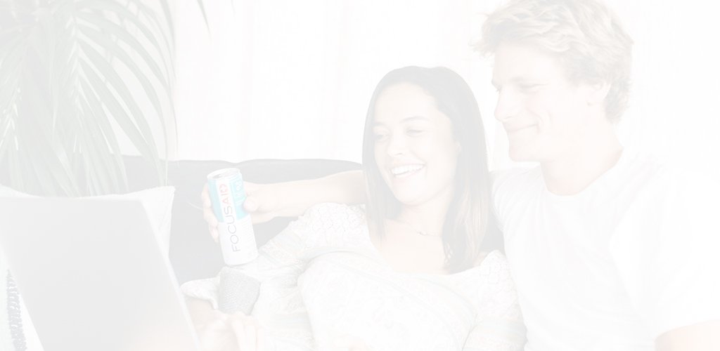 lifestyle header image of couple relaxing at home on their couch with a can of FOCUSAID, while perusing the internet together on their laptop